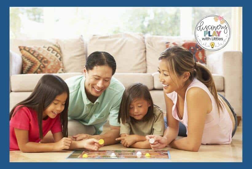 Family playing board game with 3 year old