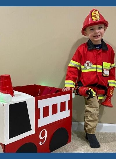 Young boy playing firefighter with fire truck