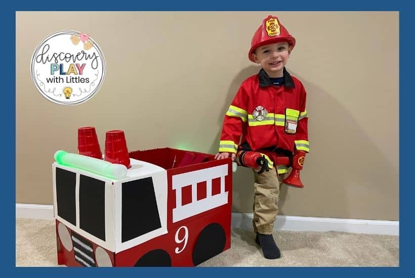 Young boy playing firefighter with fire truck
